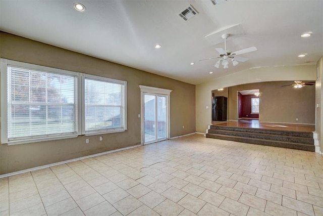 tiled spare room with a ceiling fan, plenty of natural light, visible vents, and vaulted ceiling