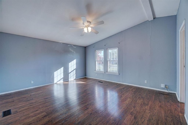 spare room featuring vaulted ceiling with beams, baseboards, visible vents, and wood finished floors