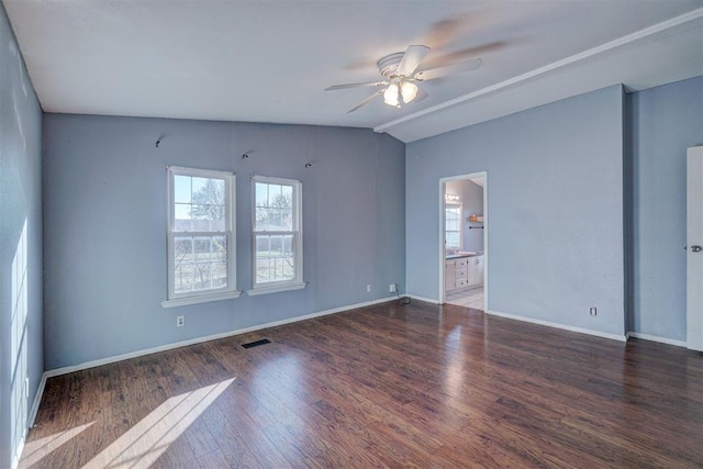 unfurnished room with visible vents, ceiling fan, vaulted ceiling, wood finished floors, and baseboards