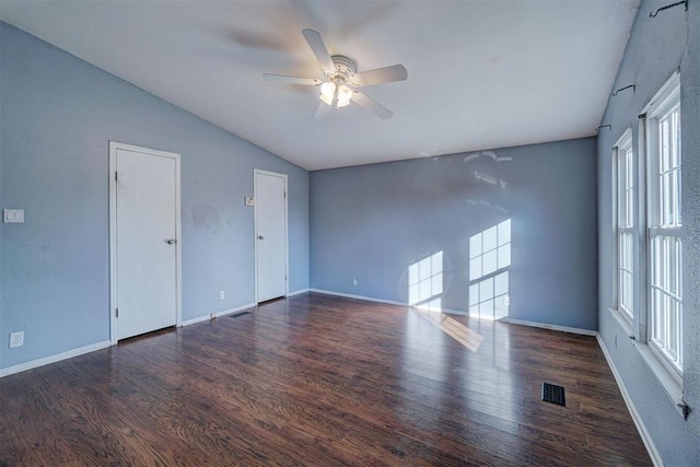 empty room with lofted ceiling, ceiling fan, wood finished floors, and baseboards