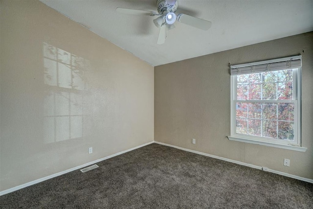 carpeted empty room featuring baseboards, visible vents, and a ceiling fan