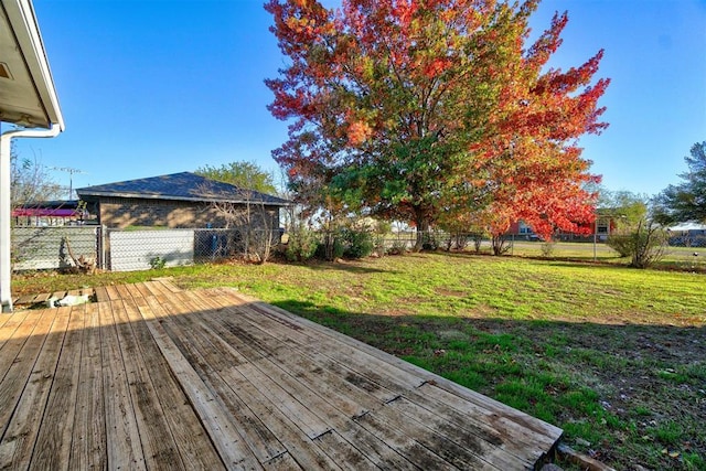 wooden terrace featuring a fenced backyard and a yard