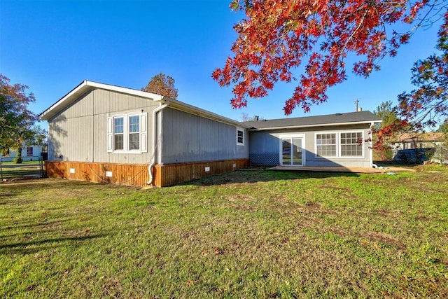 back of property with crawl space and a lawn