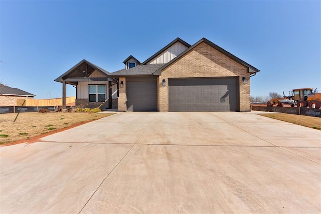 view of front of home with an attached garage, brick siding, board and batten siding, and driveway