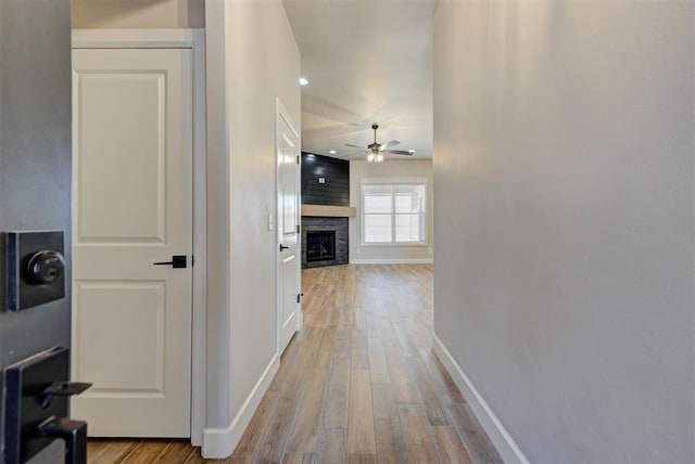 hallway with baseboards and light wood-style floors