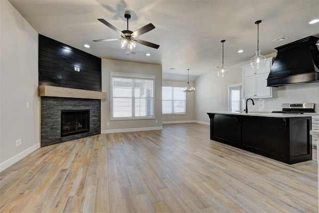 kitchen with light countertops, light wood-style floors, premium range hood, and stainless steel range with electric cooktop