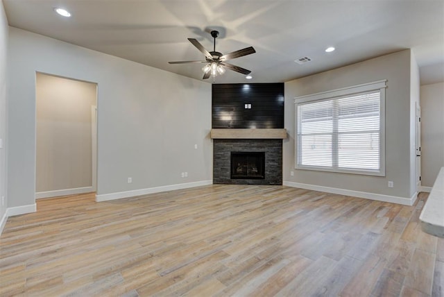 unfurnished living room with recessed lighting, a fireplace, and light wood-style floors