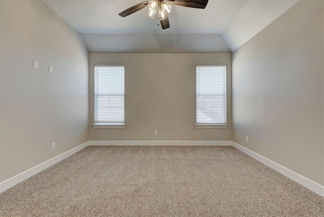 spare room featuring baseboards, light colored carpet, ceiling fan, and vaulted ceiling