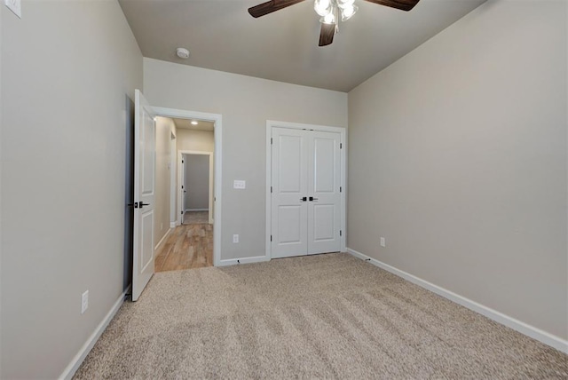 unfurnished bedroom featuring a closet, baseboards, carpet, and a ceiling fan