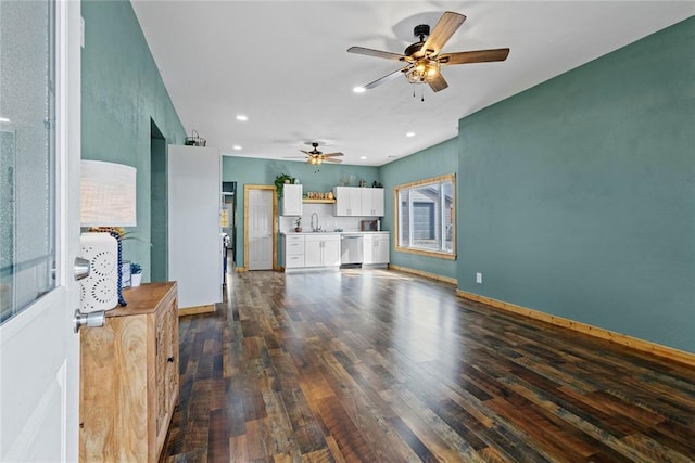 106 N Dewey St, Corn, OK 73024 - unfurnished living room with dark wood-style flooring, a sink, baseboards, and ceiling fan