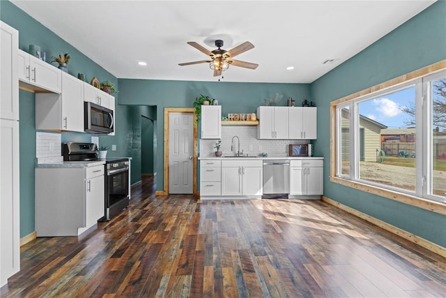 106 N Dewey St, Corn, OK 73024 - kitchen with decorative backsplash, light countertops, stainless steel appliances, white cabinetry, and a sink