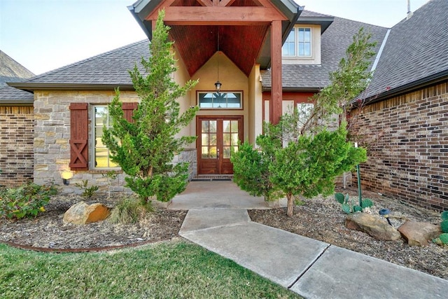 property entrance featuring stone siding, a shingled roof, brick siding, and french doors