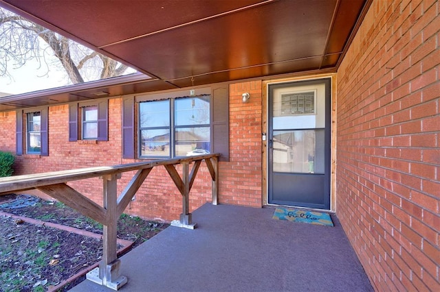 view of exterior entry with brick siding