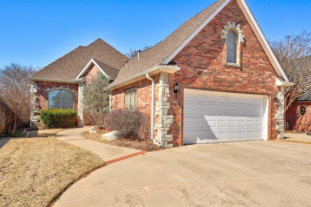 traditional-style home with a garage, concrete driveway, brick siding, and roof with shingles