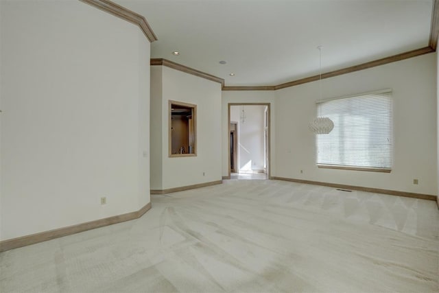 empty room featuring visible vents, ornamental molding, light colored carpet, and baseboards