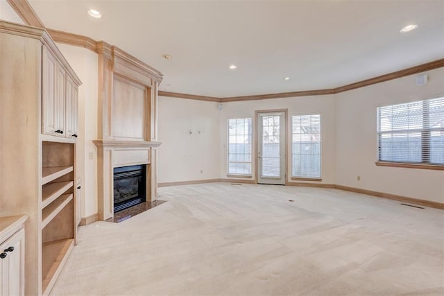 unfurnished living room with a fireplace with flush hearth, visible vents, crown molding, and light carpet