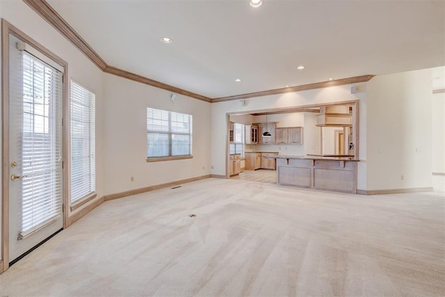 unfurnished living room with ornamental molding, light colored carpet, and baseboards