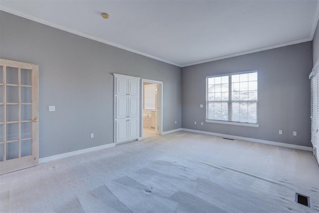 unfurnished bedroom with ornamental molding, light colored carpet, and baseboards