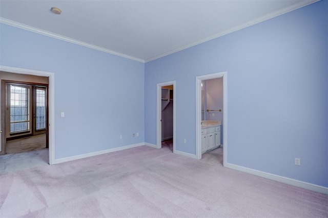 unfurnished bedroom with baseboards, a walk in closet, crown molding, and light colored carpet