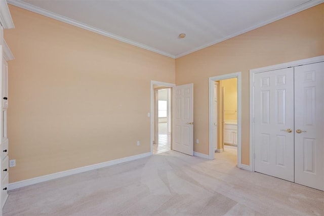 unfurnished bedroom with a closet, ornamental molding, light carpet, connected bathroom, and baseboards