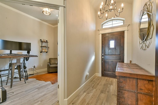 foyer featuring baseboards, a chandelier, wood finished floors, and crown molding