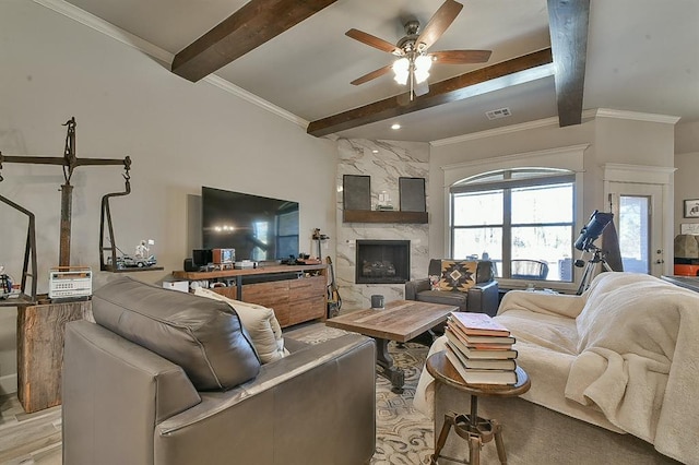 living room with beam ceiling, a high end fireplace, visible vents, and crown molding