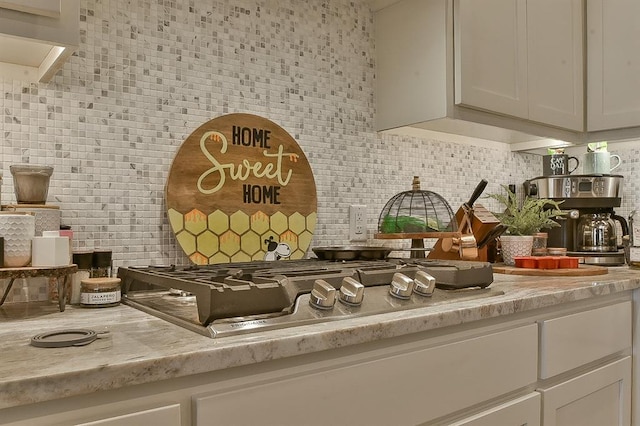 interior space with light countertops, backsplash, and white cabinetry