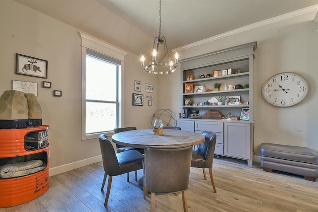 dining space with crown molding, an inviting chandelier, light wood-style flooring, and baseboards