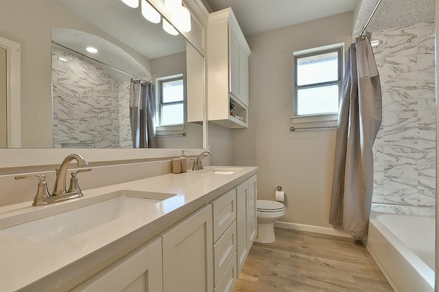 full bathroom with wood finished floors, a sink, toilet, and baseboards