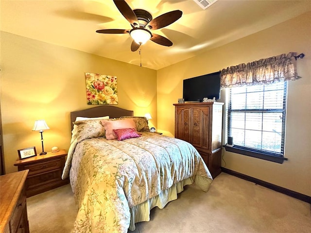 bedroom with a ceiling fan, light carpet, and baseboards