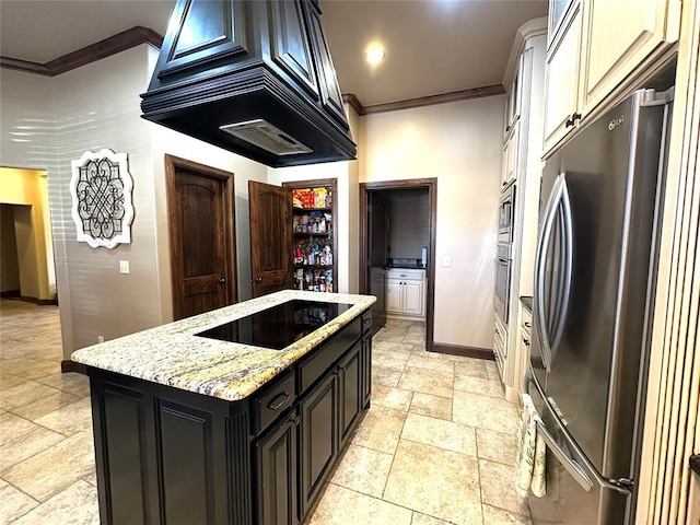 kitchen with light stone counters, stainless steel appliances, custom range hood, ornamental molding, and baseboards