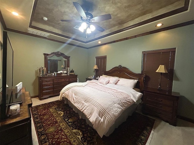 bedroom featuring ceiling fan, recessed lighting, ornamental molding, a tray ceiling, and carpet