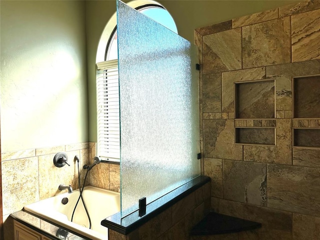 full bathroom featuring a bath and tiled shower