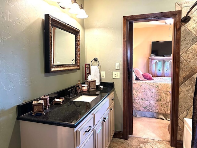 bathroom featuring a textured wall, connected bathroom, and vanity