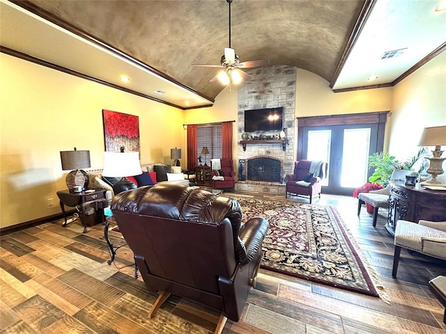 living room with visible vents, baseboards, hardwood / wood-style flooring, vaulted ceiling, and a stone fireplace