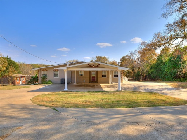 view of front of home with driveway, a front yard, and stucco siding