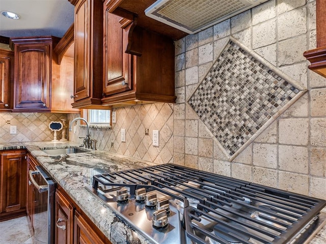 kitchen featuring light stone countertops, stainless steel appliances, a sink, ventilation hood, and decorative backsplash