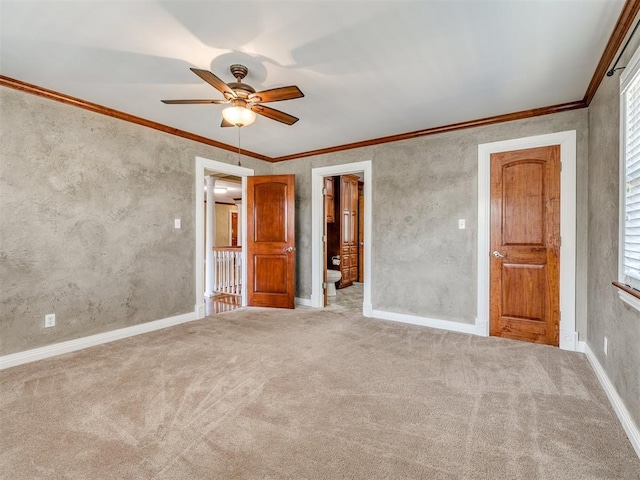 unfurnished bedroom featuring a ceiling fan, baseboards, ornamental molding, and carpet flooring