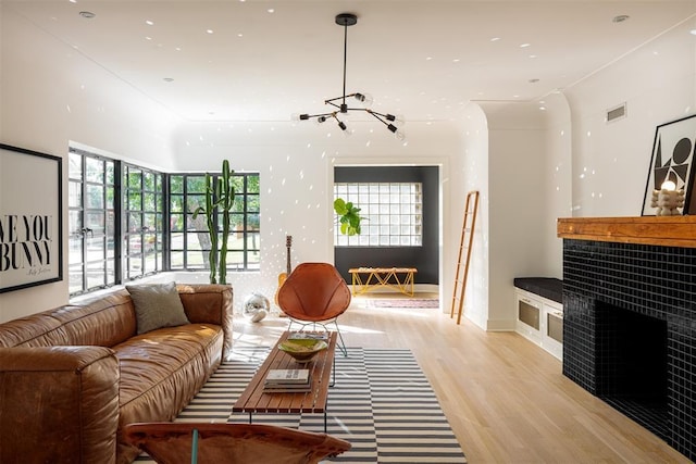 living area with light wood-type flooring, a chandelier, a fireplace, baseboards, and recessed lighting