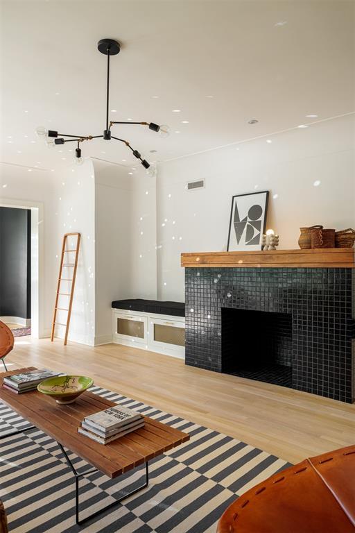 living room featuring a tiled fireplace and light wood finished floors