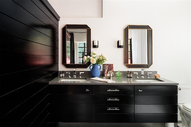bathroom with double vanity and toilet