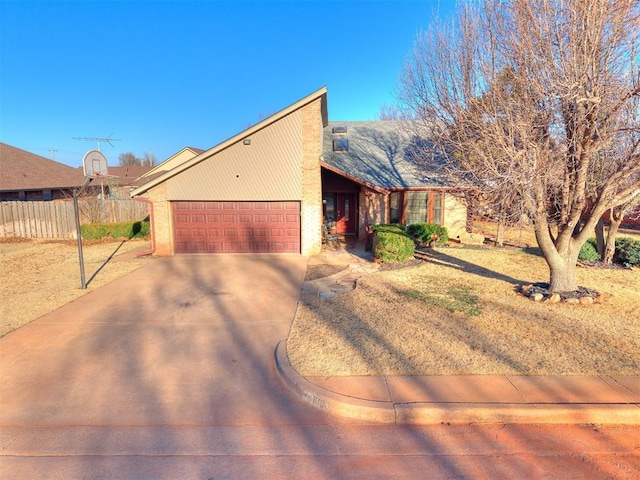 view of front of property featuring concrete driveway, fence, and an attached garage