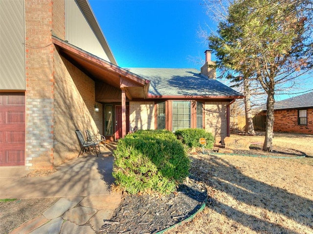 exterior space with brick siding and a chimney