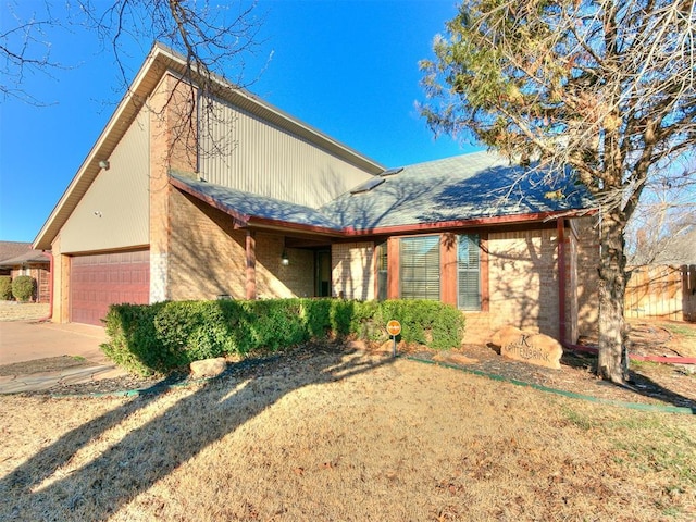 view of front facade with an attached garage, brick siding, driveway, and roof with shingles