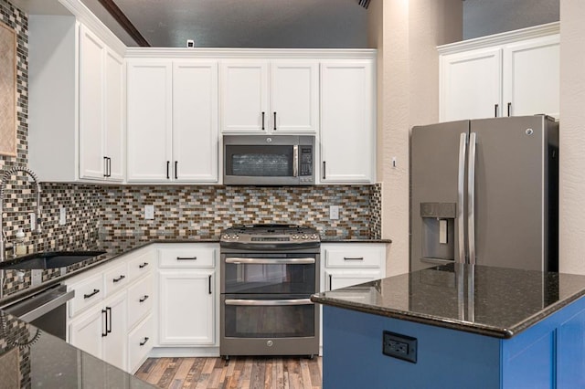 kitchen with white cabinetry, decorative backsplash, stainless steel appliances, and a sink