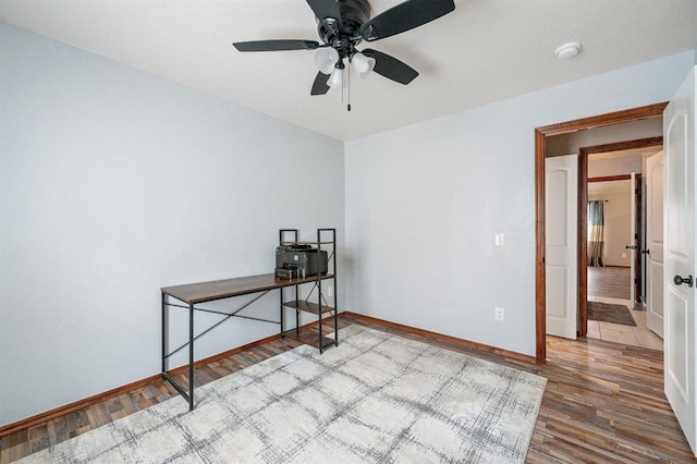 unfurnished room featuring ceiling fan, baseboards, and wood finished floors