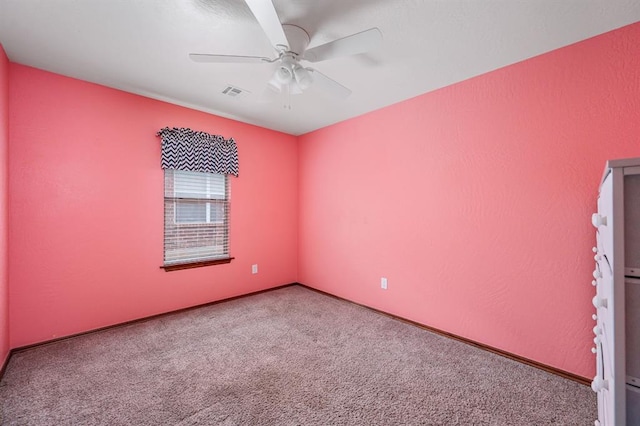 spare room with baseboards, visible vents, a ceiling fan, and carpet flooring