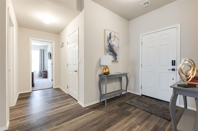 foyer with dark wood-style flooring, visible vents, and baseboards