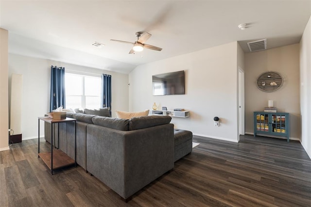 living area with a ceiling fan, lofted ceiling, visible vents, and dark wood finished floors