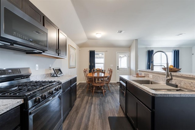 kitchen with a sink, visible vents, stainless steel gas range, a wealth of natural light, and dark wood finished floors